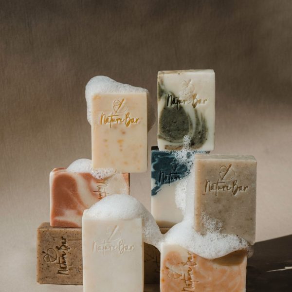 Gentle oatmeal and goat milk bars lathering on a dark background